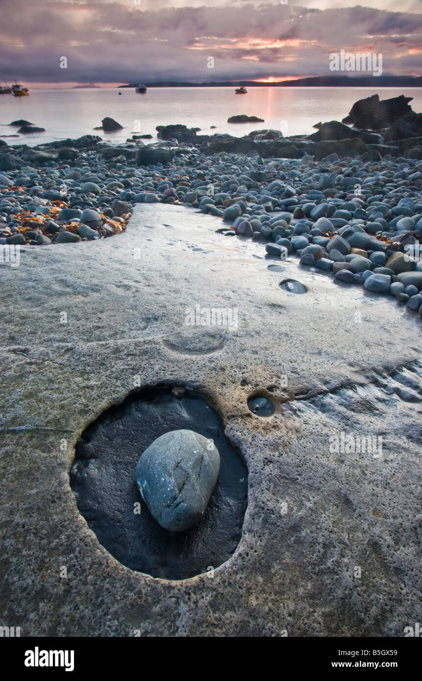 Unglaubliche erodierte Kalkstein Bettwäsche und Kieselsteine am Strand von Elgol, mit dem Hafen im Hintergrund. Stockfoto