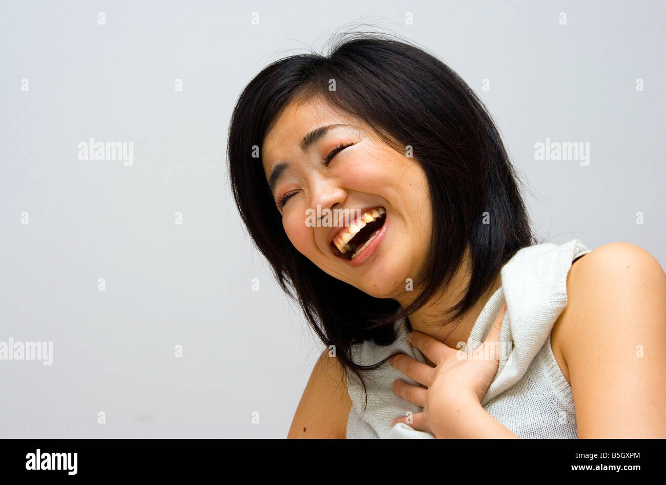 Schöne orientalische Frau in einem weißen Hemd mit Kragen lachen Stockfoto