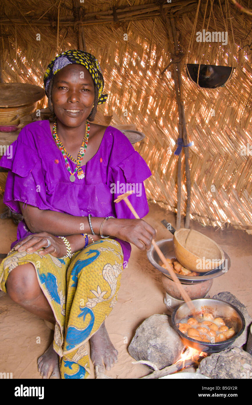 Eine Frau in einem kleinen Dorf im südwestlichen Niger kocht "Fari Masas" innerhalb ihrer traditionellen Haus aus Stroh. Stockfoto