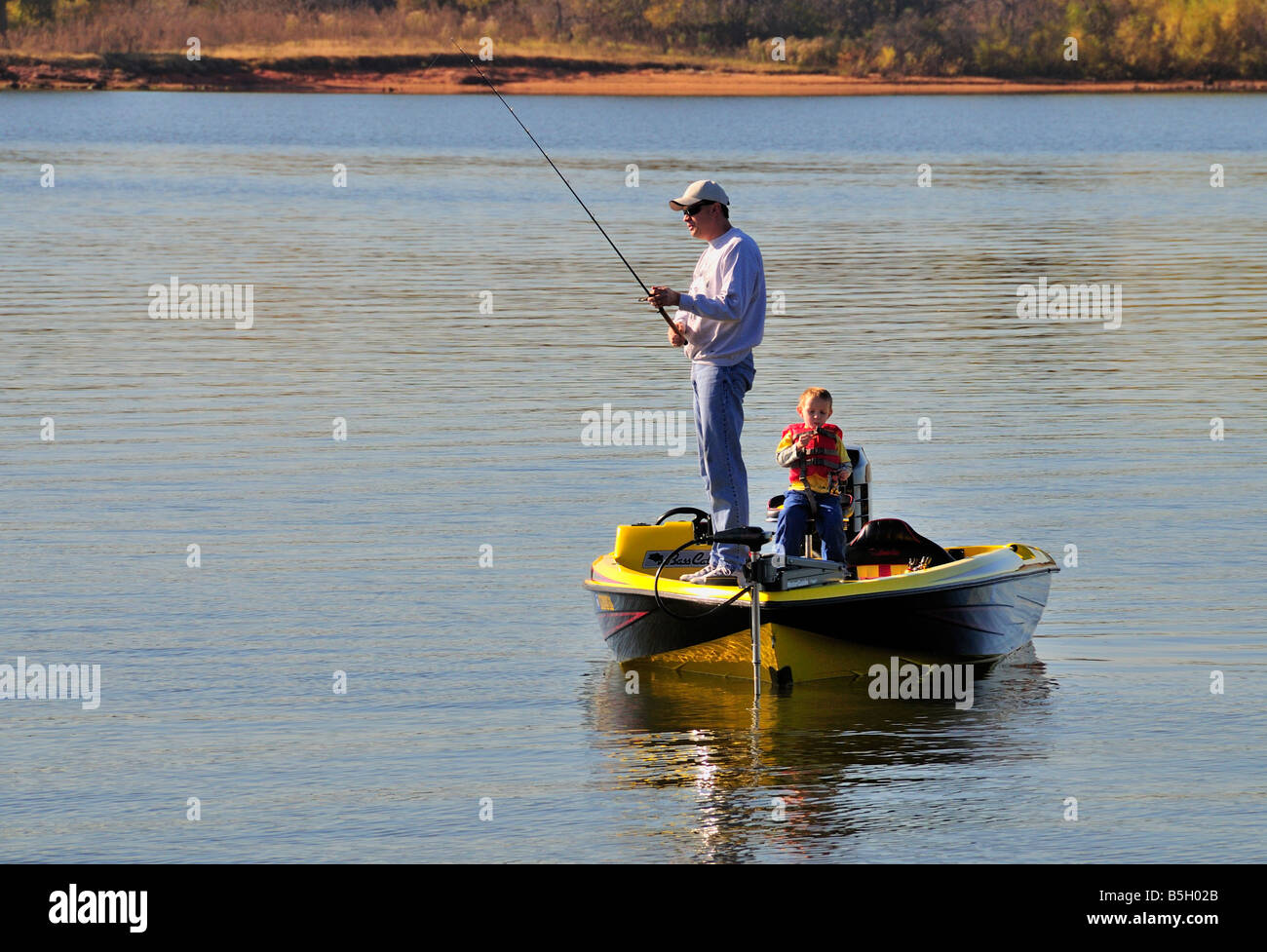 Ein Vater Fische aus seinen Bass Boot, während sein kleiner Sohn Uhren. Arcadia Lake, Oklahoma, USA. Stockfoto