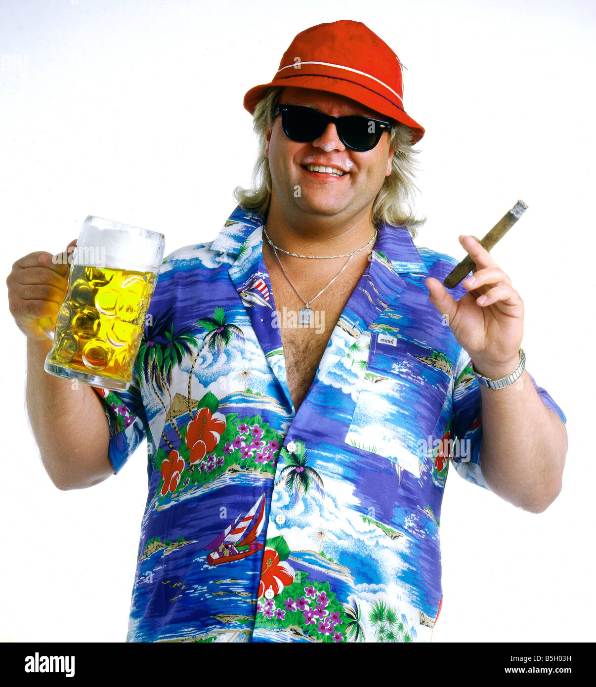 Glücklich Mitte Alter Biertrinker mit einem Bierglas und Zigarre in einem Hawaii-Hemd mit Sonnenbrille lächelnd in die Kamera. Stockfoto