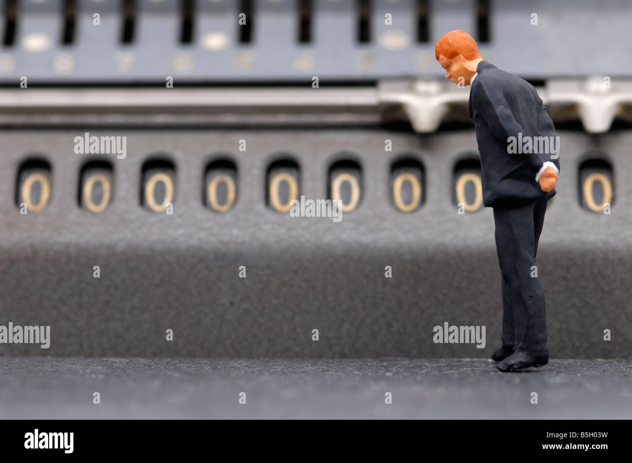 Abbildung eines Geschäftsmannes vor eine Rechenmaschine, Symbol der Insolvenz Stockfoto