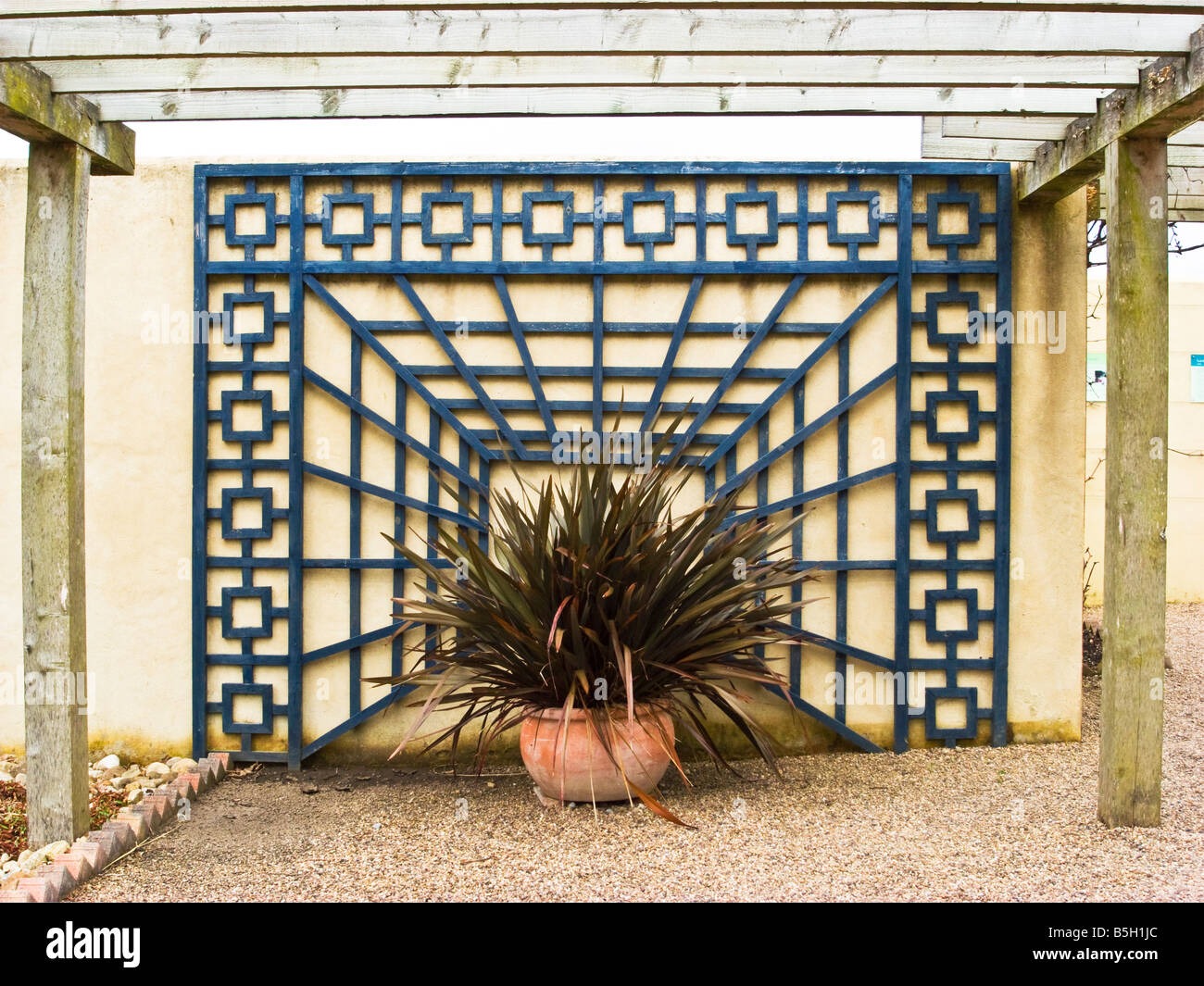 Gartengestaltung mit ornamentalen Spalier an einer Wand Stockfoto