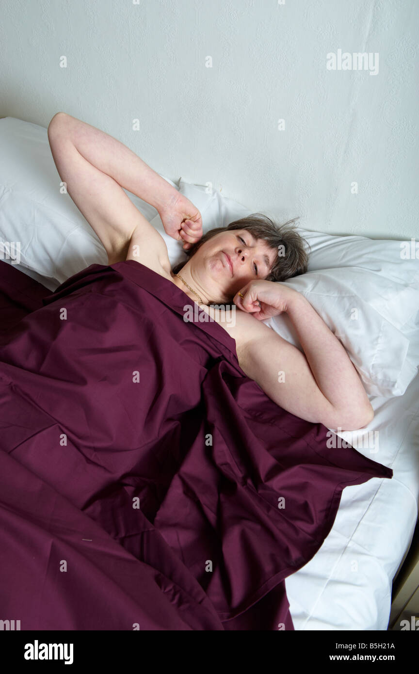 Frau im Bett vor dem Aufstehen Strecken Stockfoto