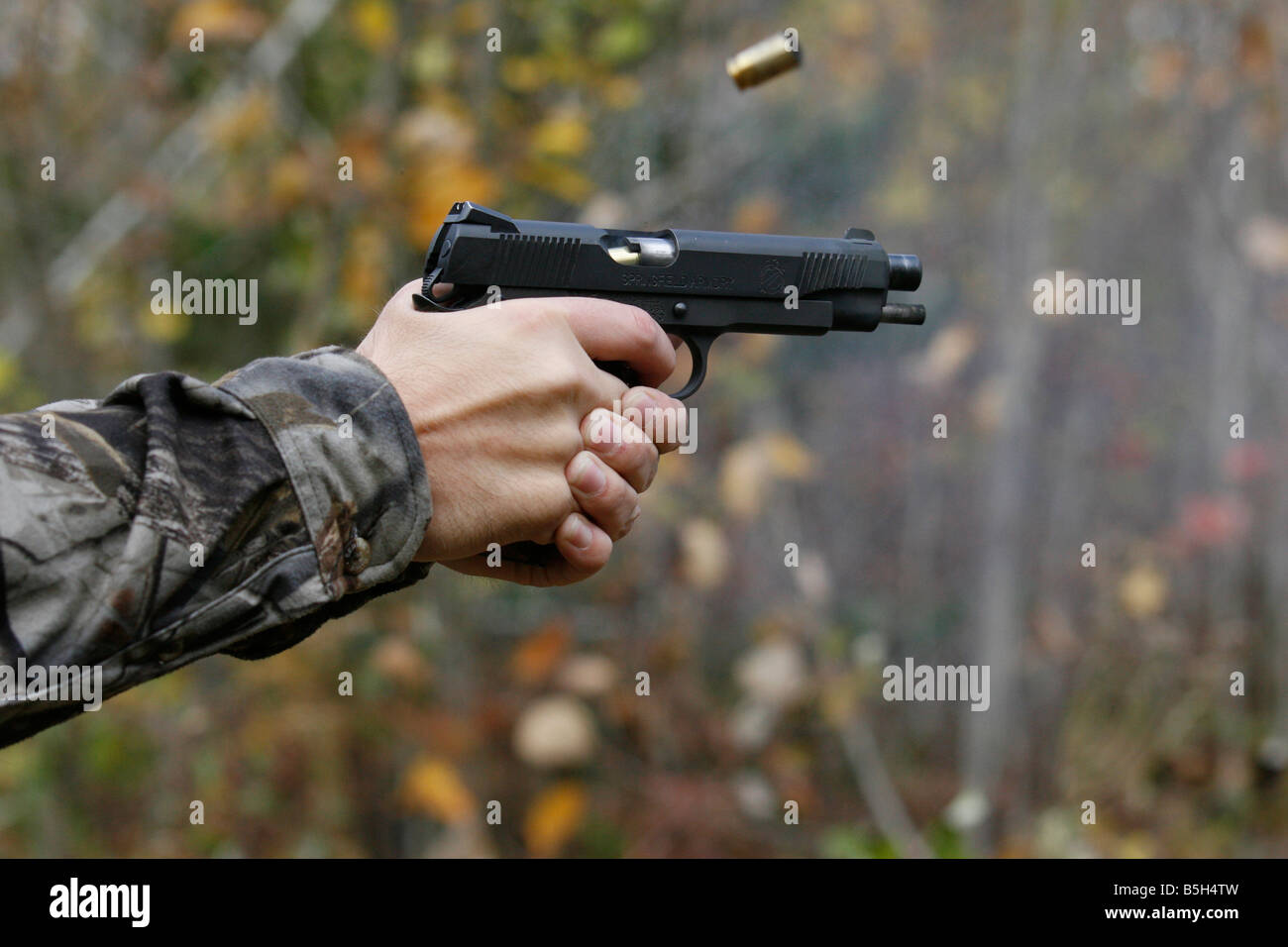 Nahaufnahme einer Colt 45 halbautomatische Pistole abgefeuert mit der leeren Hülse wird ausgeworfen. Stockfoto