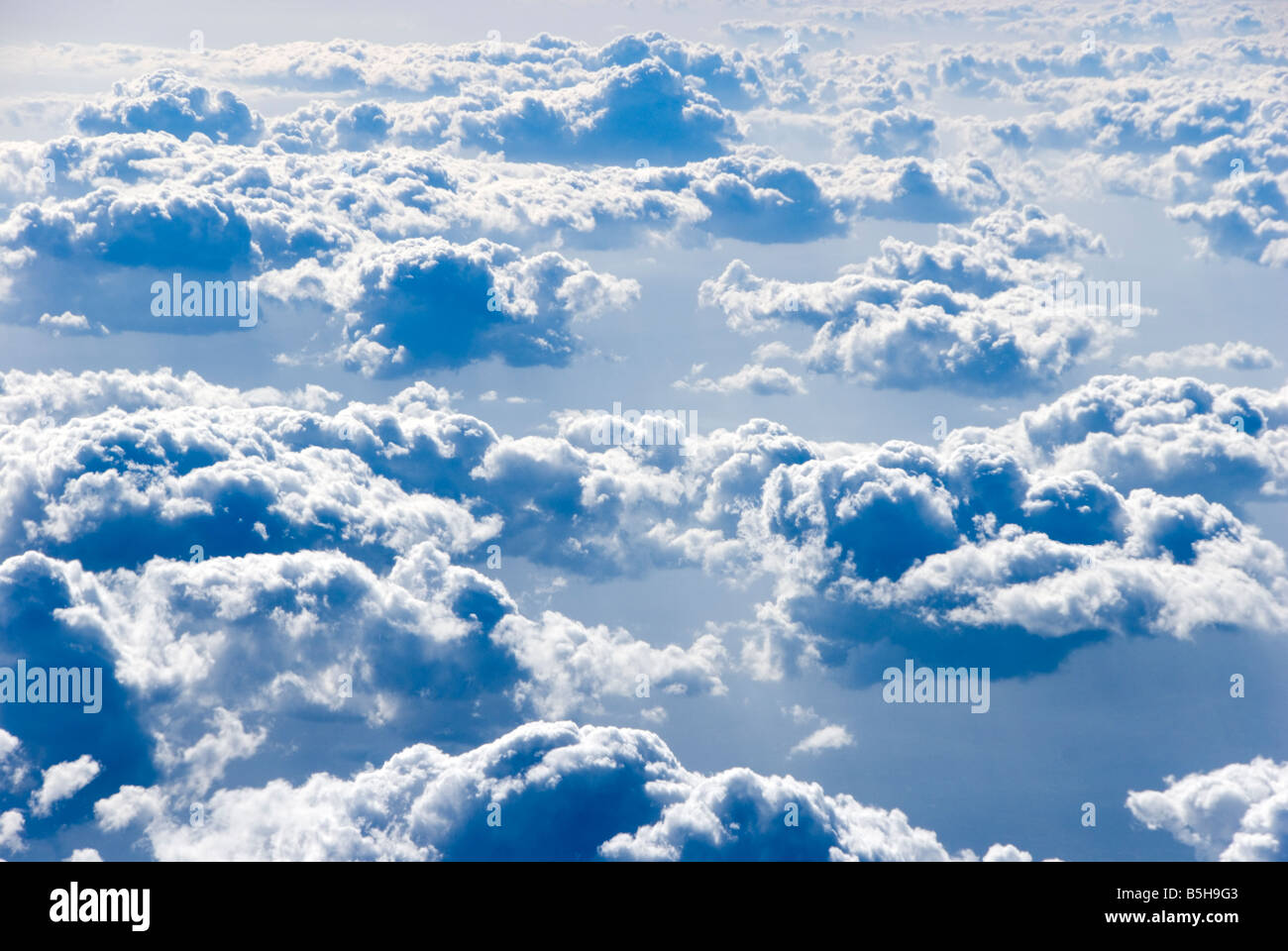 Zeigen Sie über flauschigen Wolken in großer Höhe an Stockfoto