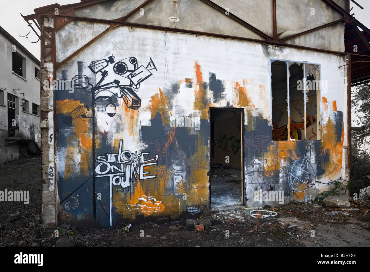 Graffiti in einer Brownfield-Website-Fabrik. Graffiti Bild auf der Wand zeigt CCTV-Kameras Stockfoto