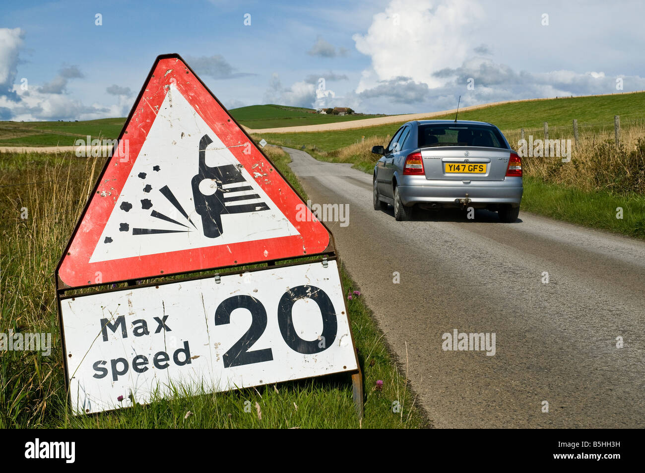 dh Straßenschild STRASSE Großbritannien verlieren Chippings Warnschild 20 mph höchstgeschwindigkeit Auto auf der Straße Geschwindigkeitsbegrenzung Verkehrszeichen rot Dreieck schottland Stockfoto