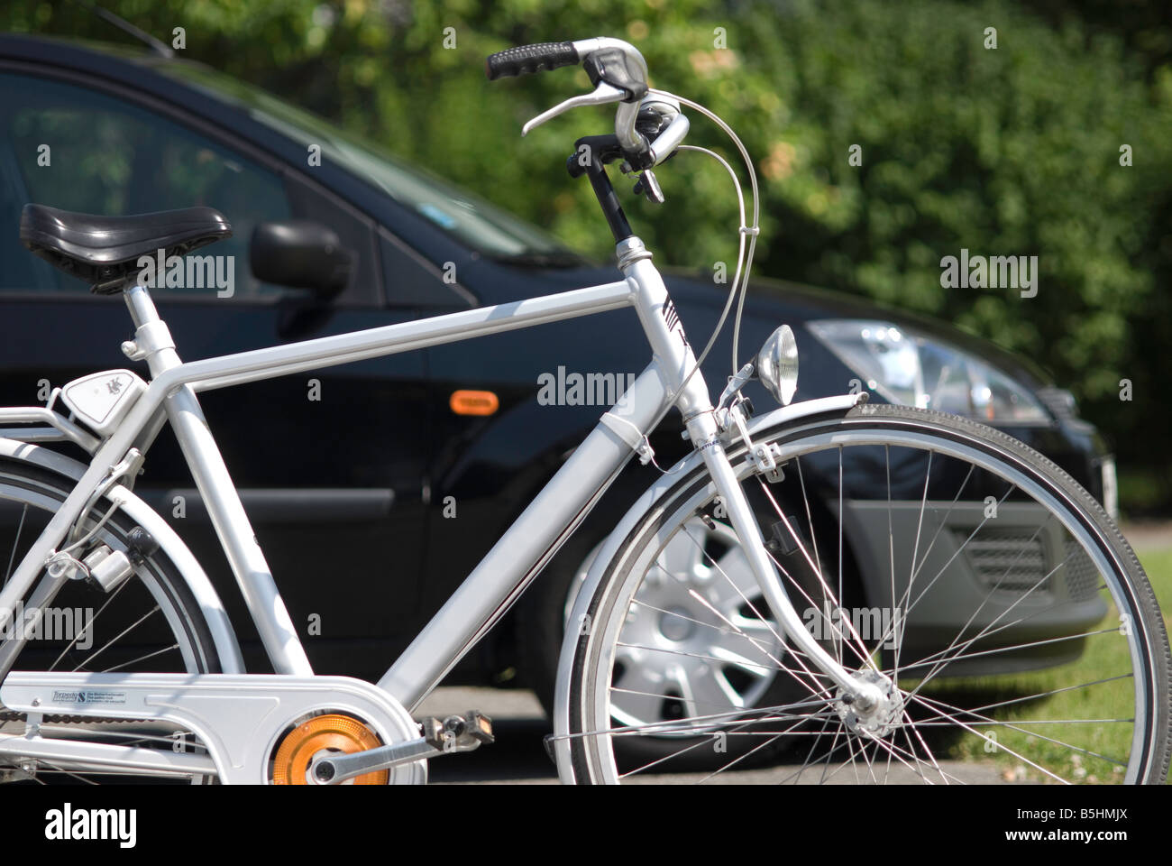 Fahrrad vor einem Auto, gehendes Grün Stockfoto