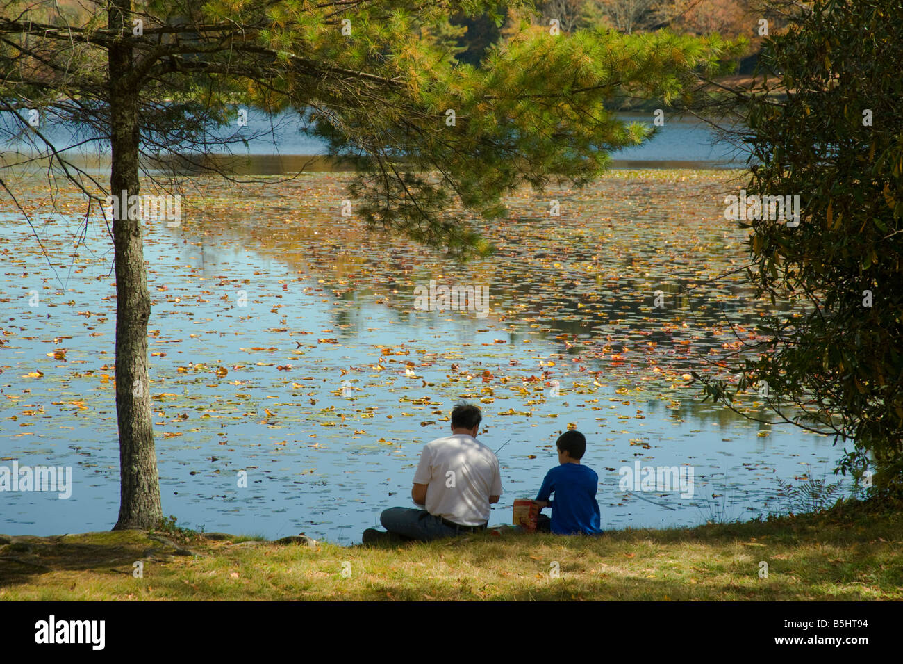 Mann und der junge sitzen am See Stockfoto