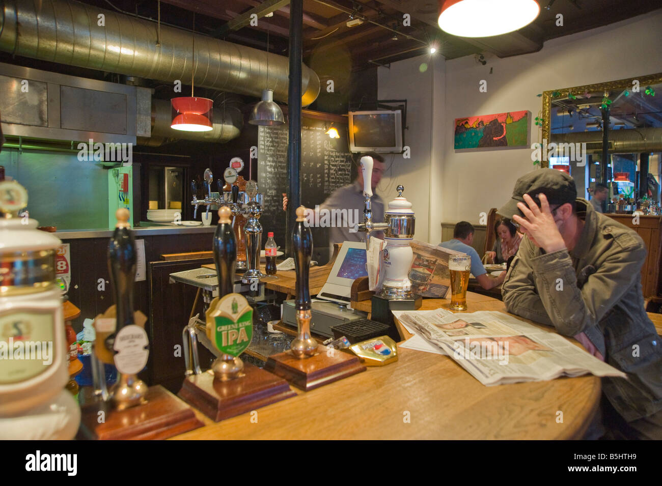 Ein Mann liest eine Zeitung in Warwick Castle, Pub, Portobello Road Nottinghill London W11 Stockfoto