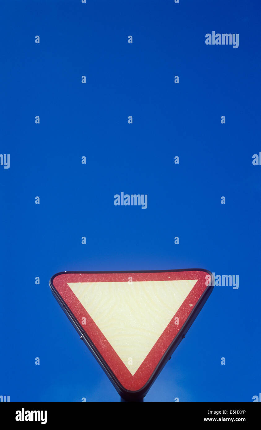 Leeren roten und weißen Kopf dreieckig Roadsign geben Vorwarnung der Vorfahrt oder Haltelinie bei blauem Himmel Stockfoto