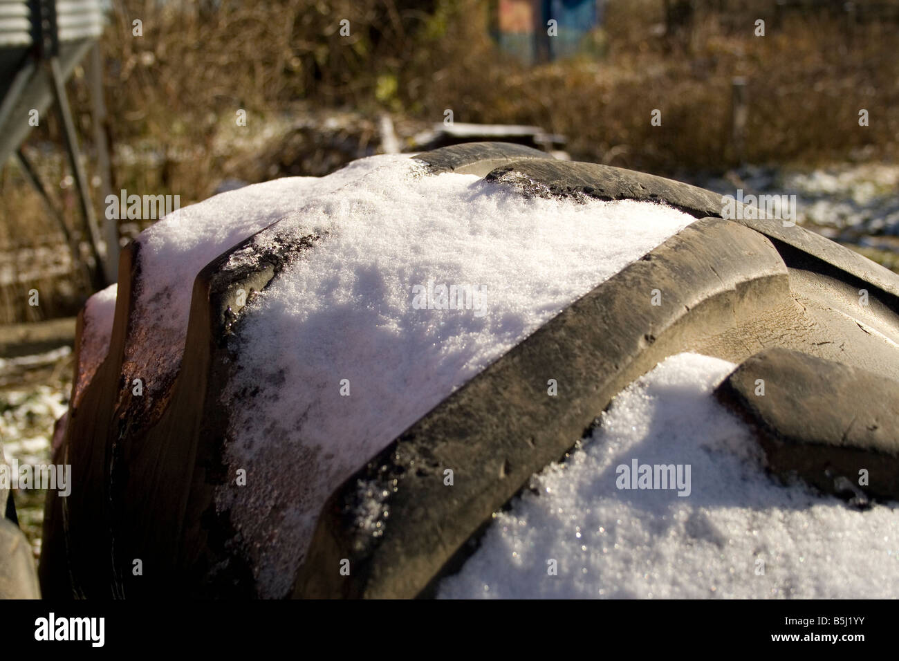 Die Spitze des Schnees abgedeckt Traktorreifen Stockfoto