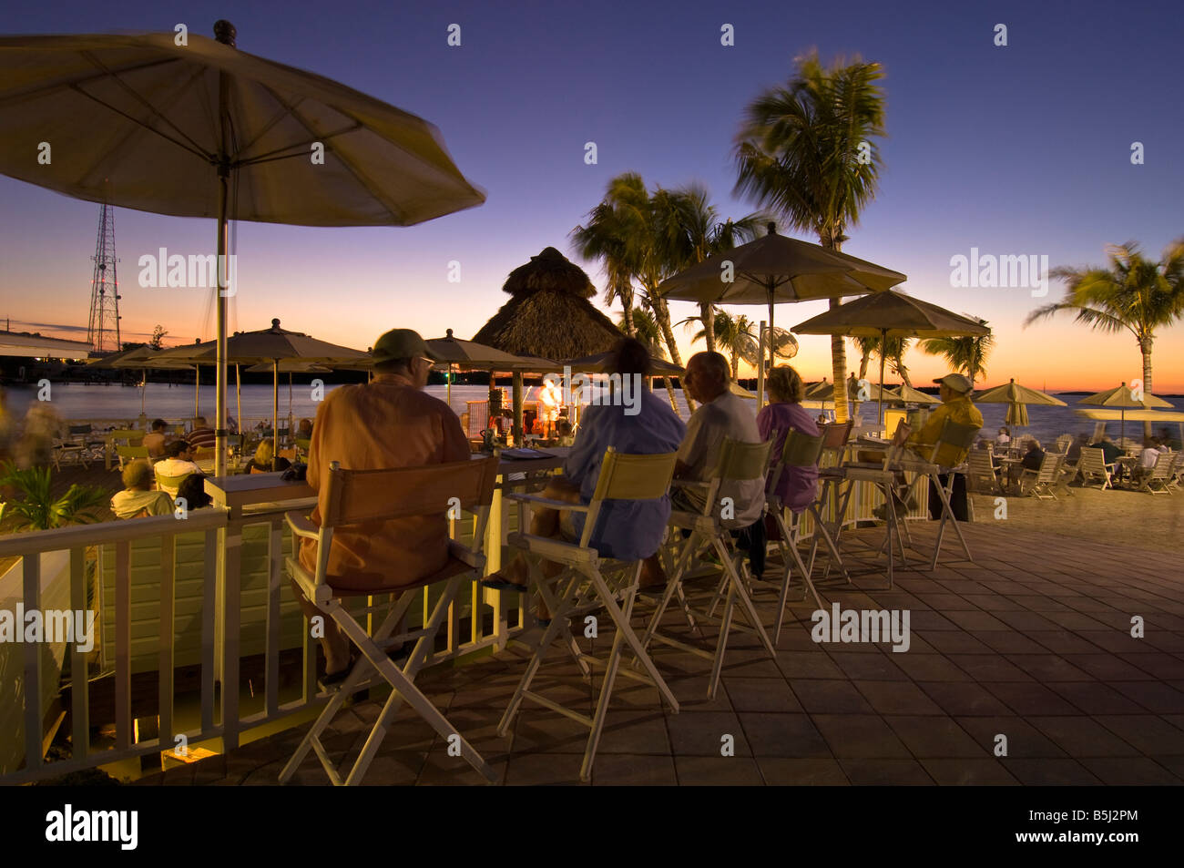 Vereinigte Staaten von Amerika Florida Florida Keys Islamorada Lorelei Resortgäste an der Bar den Sonnenuntergang über dem Ozean Stockfoto