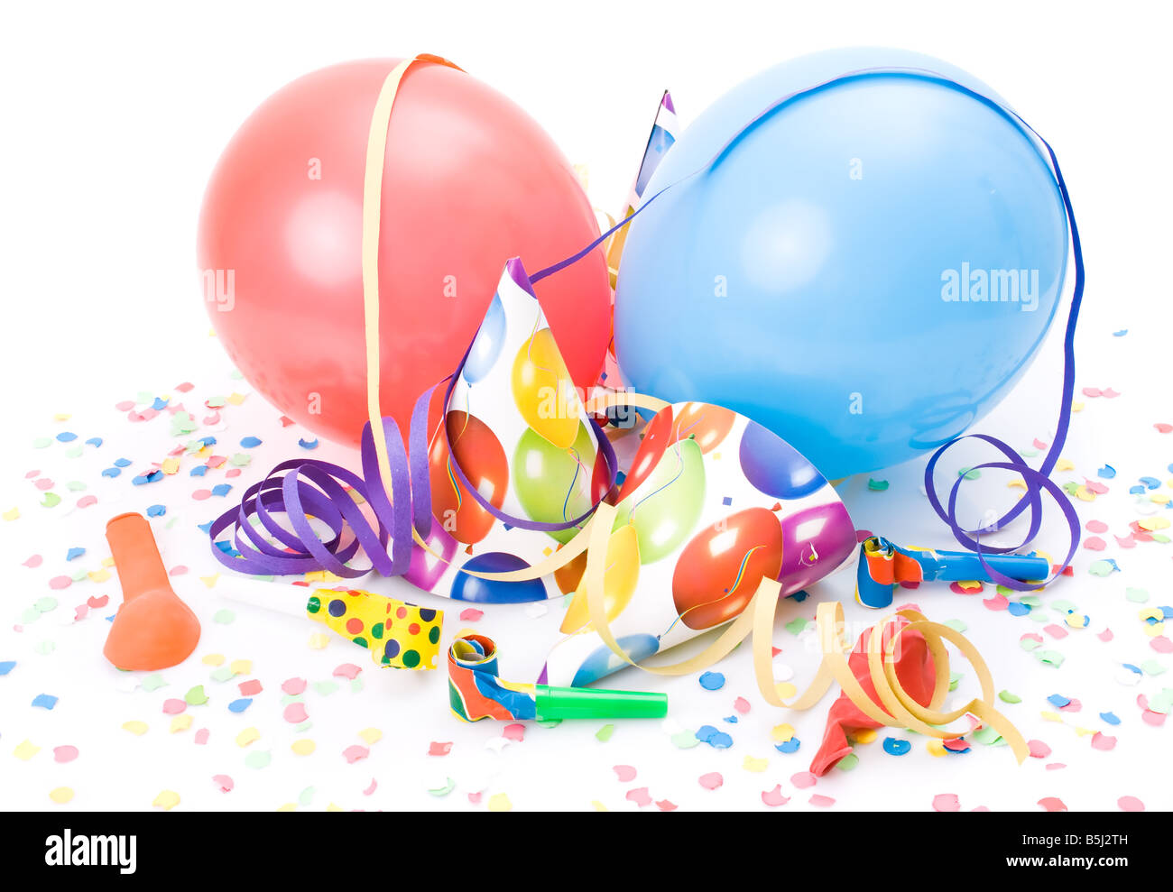 Partyhüte, Hörner oder Pfeifen, Confettis und Luftballons auf weißem Hintergrund. Stockfoto