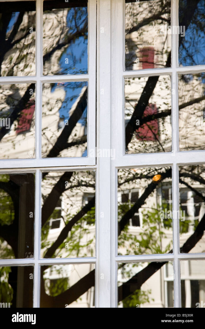 Amsterdamer Grachtenhäuser spiegelt sich in einem Fenster im Frühling. Stockfoto