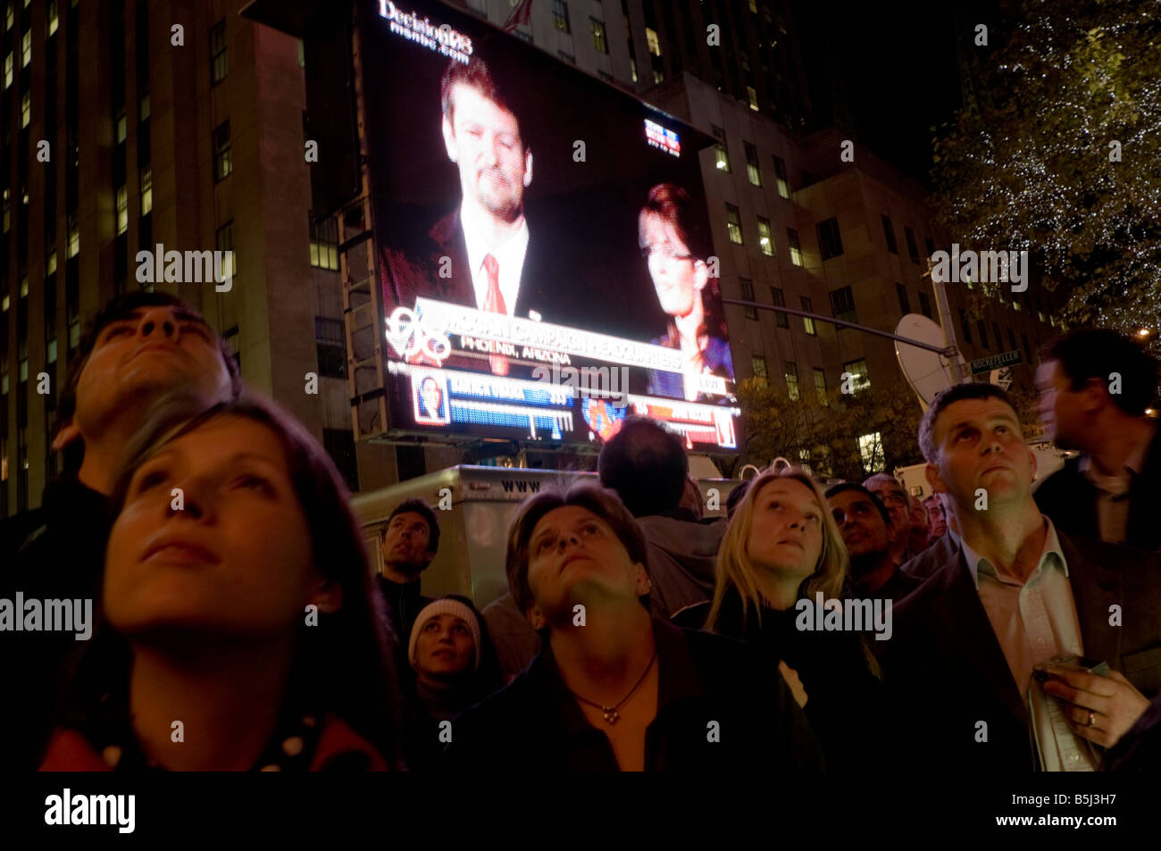 Menschenmenge versammelte sich in Rockefeller Plaza, Wahlergebnisse zu sehen. Sarah Palin und ihr Mann sind auf der großen Leinwand gezeigt. Stockfoto