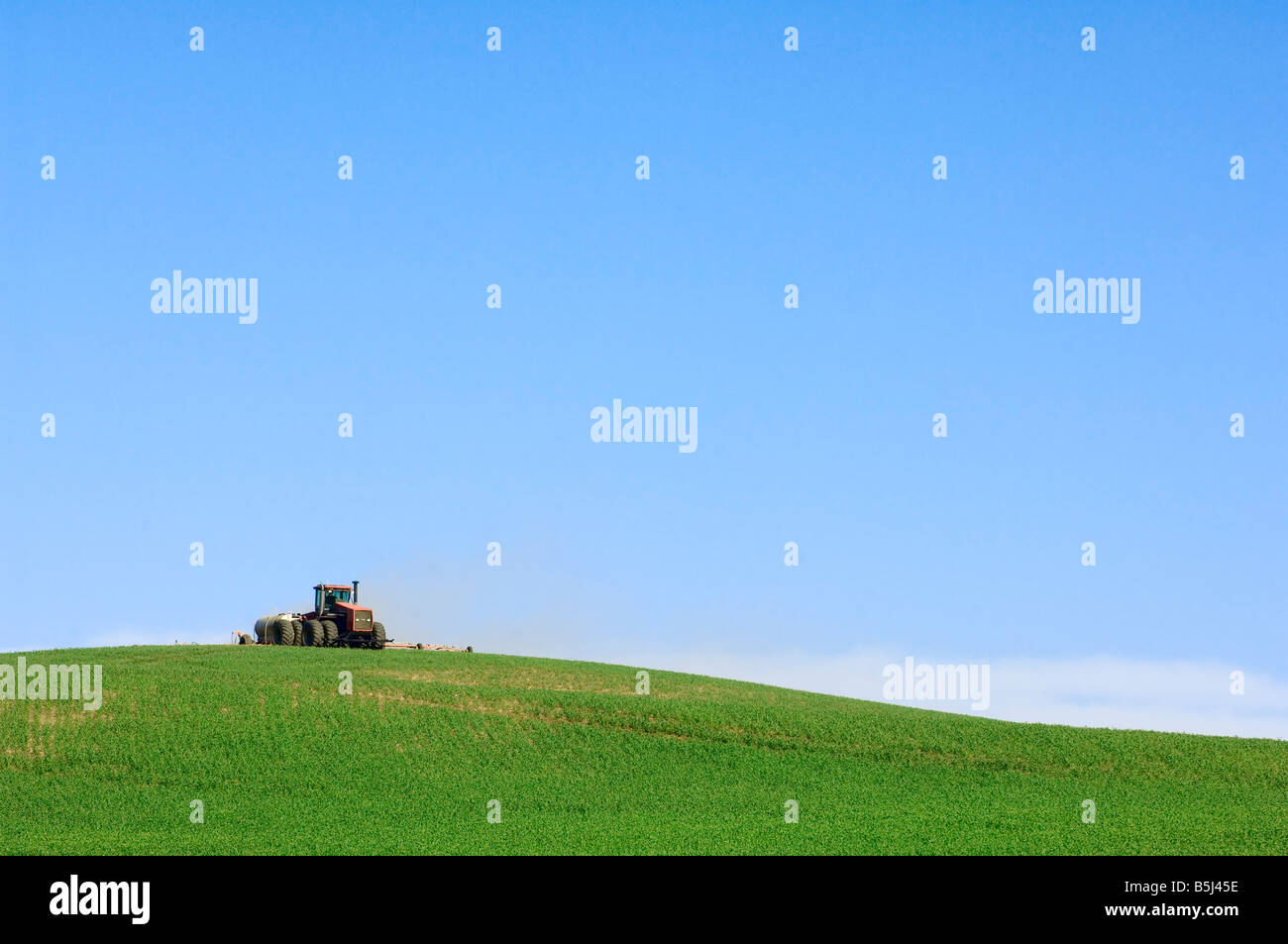 Ein Traktor zieht einen Sprüher sprüht Garbanzo Bohnen im Frühjahr in der Palouse Region Washington Stockfoto