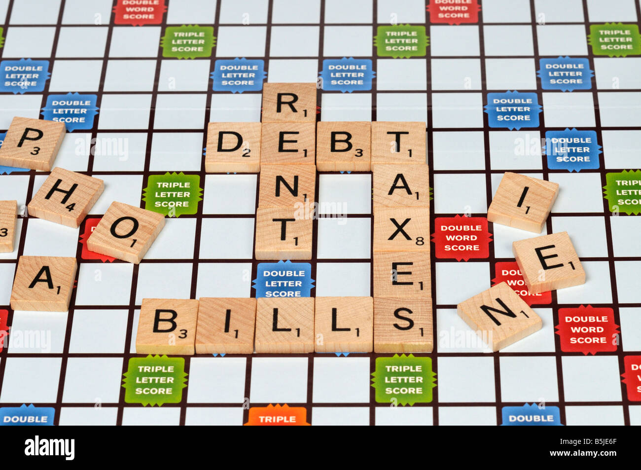 Scrabble Fliesen Rechtschreibung Wörter Miete, Schulden, Steuern, Rechnungen Stockfoto