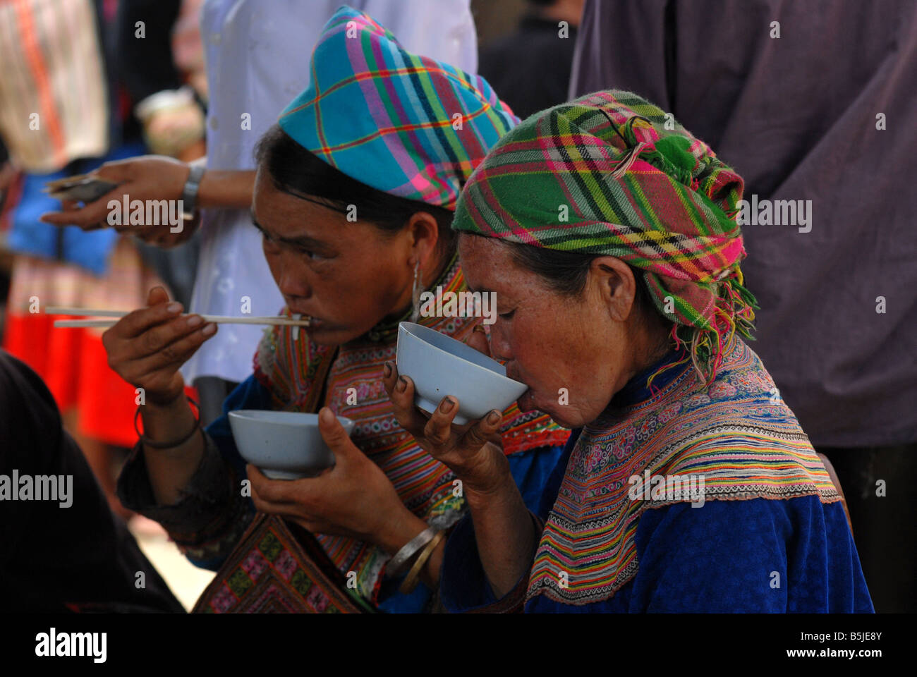 Flower Hmong mit einer Mahlzeit auf dem Markt von Bac Ha Dorf Nord-Vietnam Stockfoto