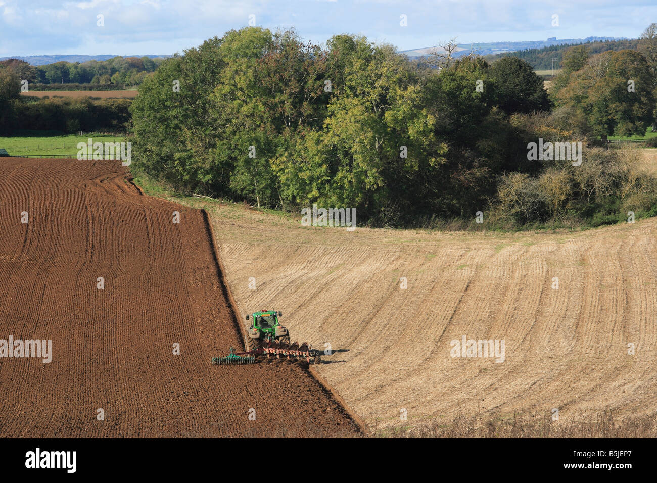 Landwirt in Traktor pflügen ein Feld Stockfoto