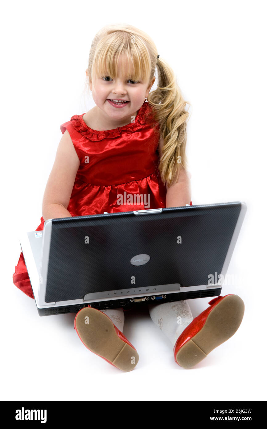 Kind im roten Kleid spielen oder Laptop Computergerät. Stockfoto