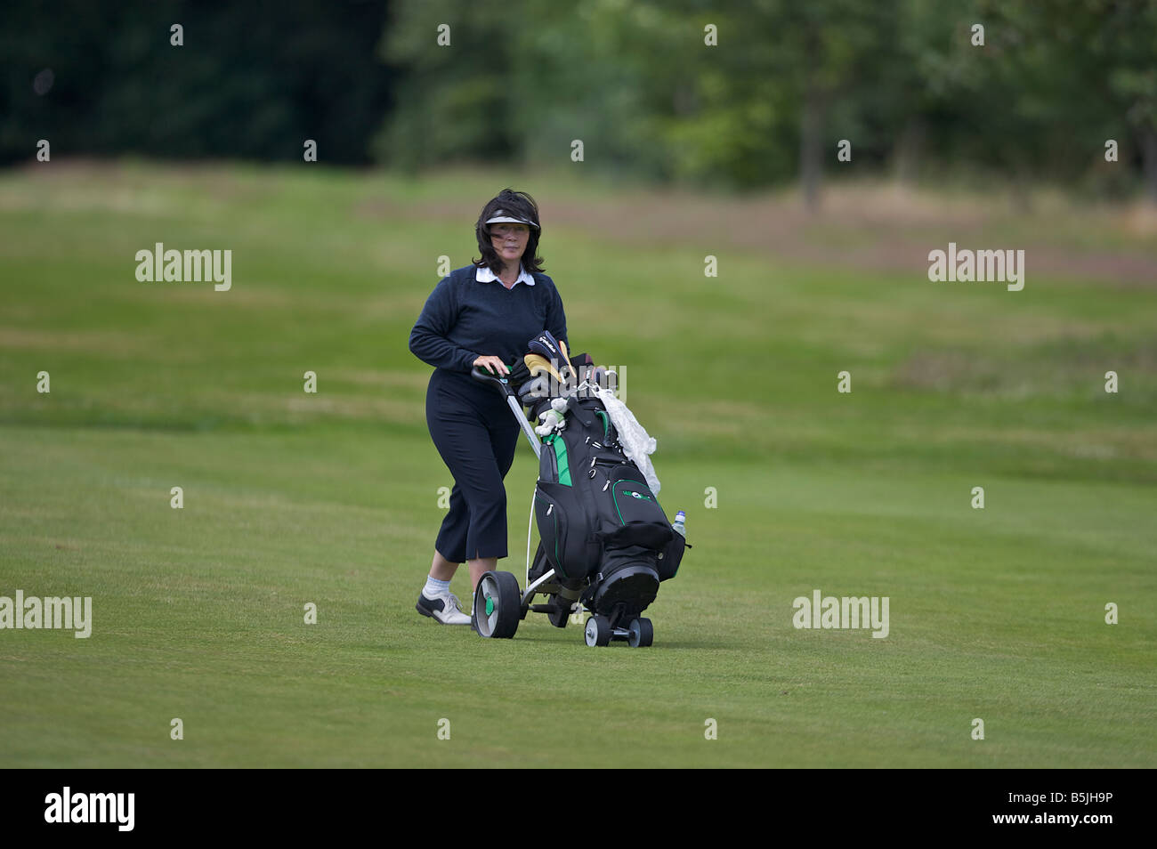 Lady Golfer eine Fahrrinne hinunter, während einer Runde golf Stockfoto