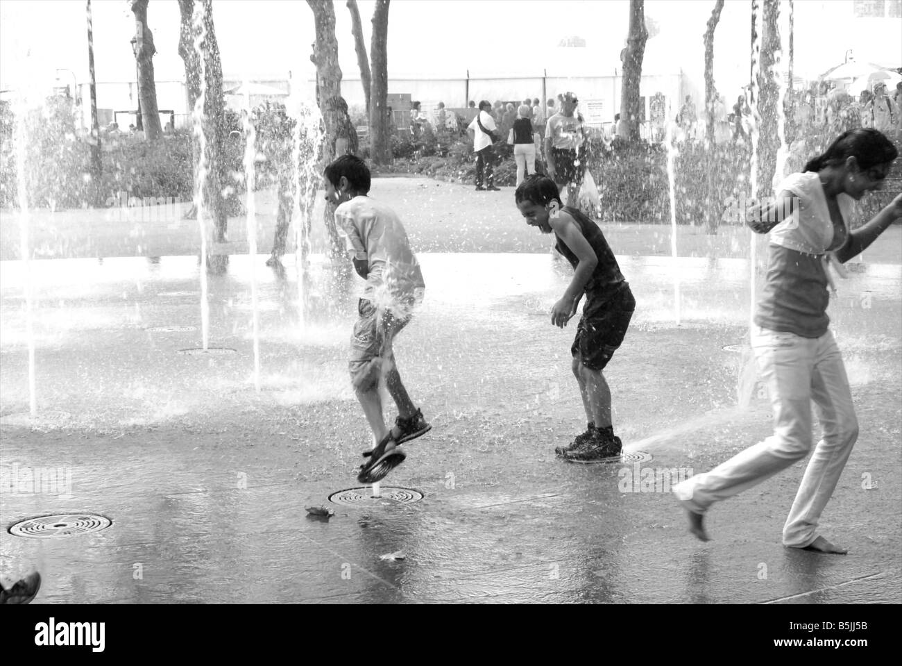 Kinder spielen in den kühlen Brunnen am Battery Park an einem heißen Sommertag in New York Stockfoto