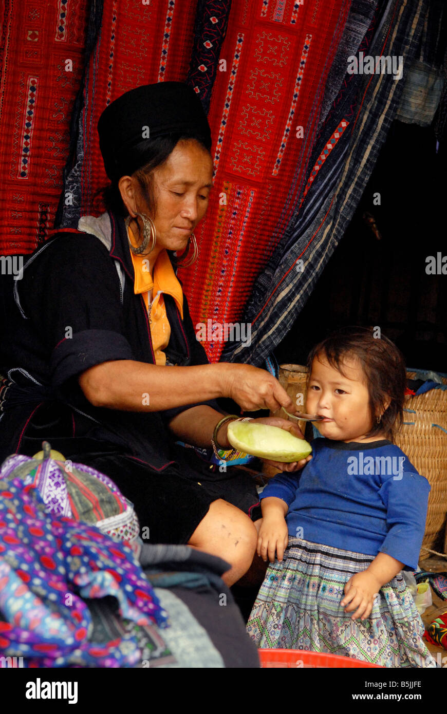 Füttern ihr Kind im Marktgebiet Nord-Vietnam Sapa Black Hmong-Frau Stockfoto