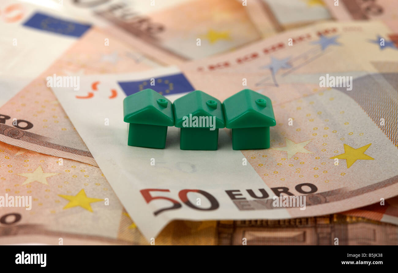drei grüne Häuser oben auf einem Stapel von 50 Euro-Banknoten-Bargeld Stockfoto