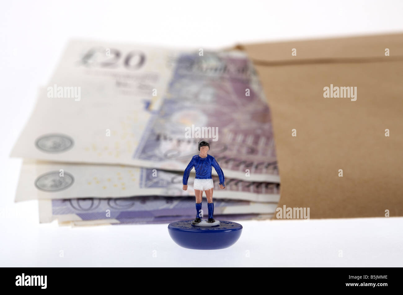 Bündel von 20 Pfund Sterling Banknoten Bargeld in einer braunen Papierumschlag hinter Spielzeug Fußballer Stockfoto