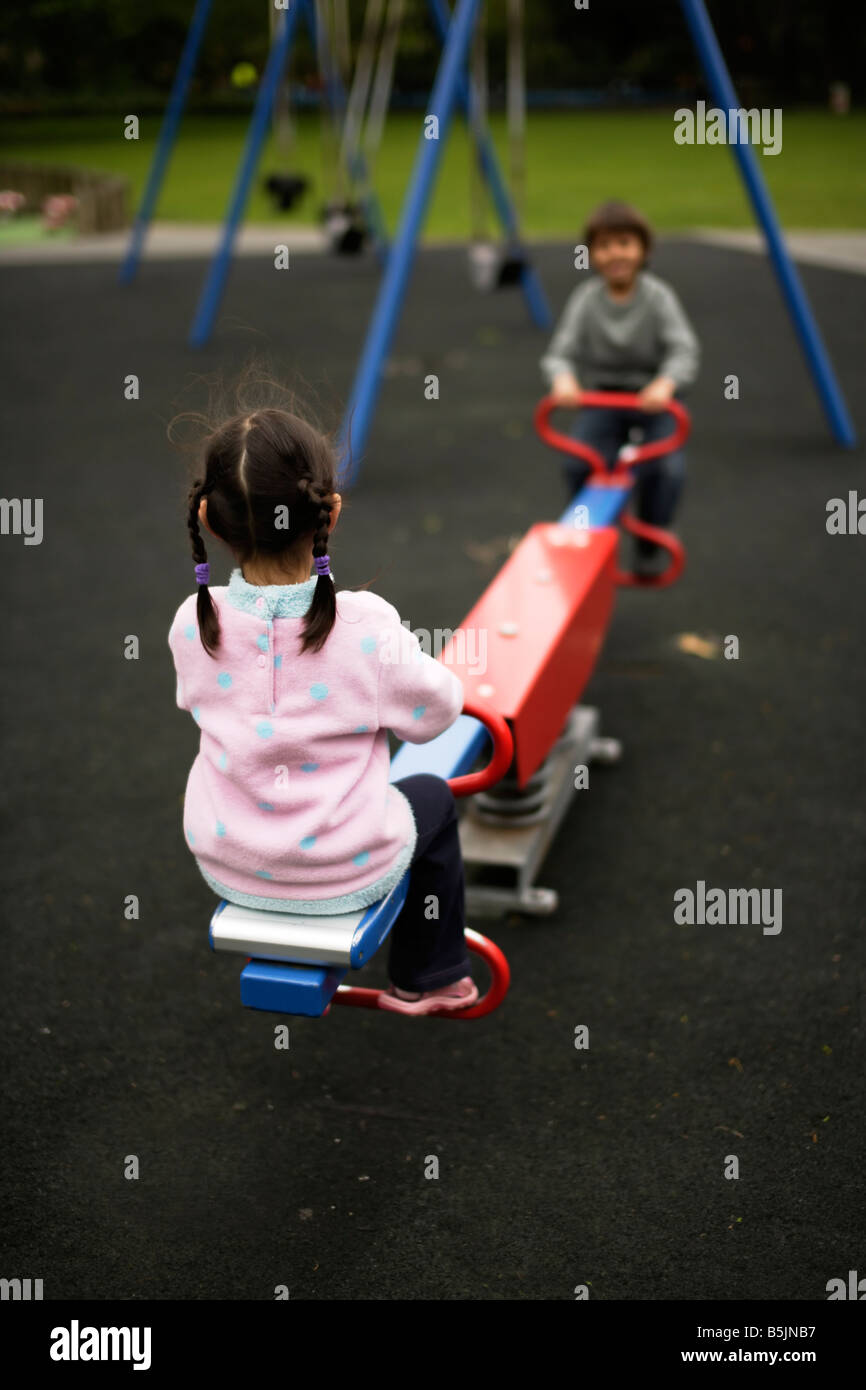 Sechs Jahre alte Junge spielt im Park auf Wippe mit fünf Jahre alte Schwester Stockfoto
