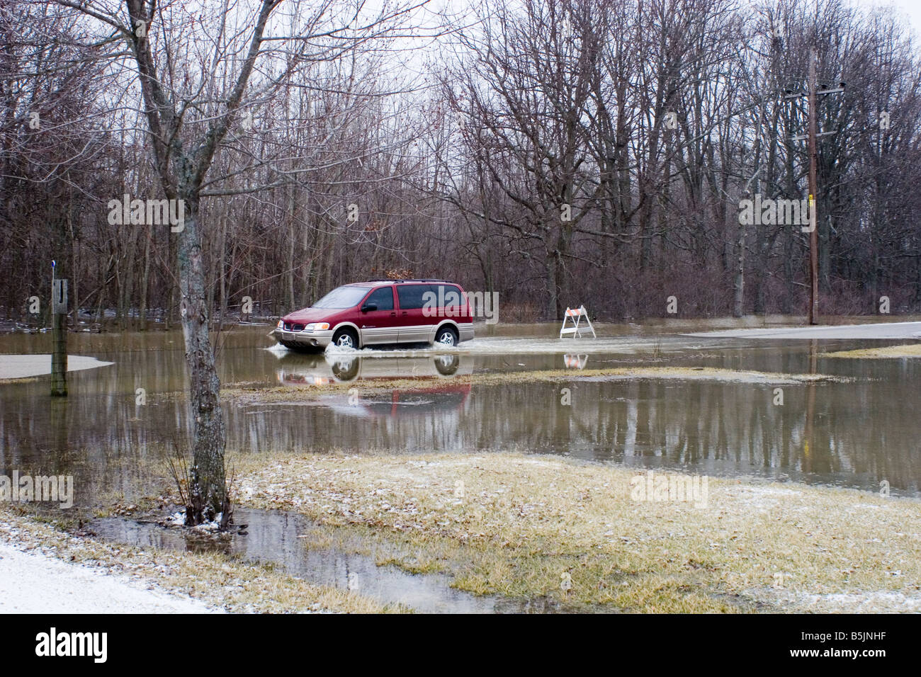 Auto fahren langsam durchs Wasser Überschwemmungen über eine Straße Stockfoto