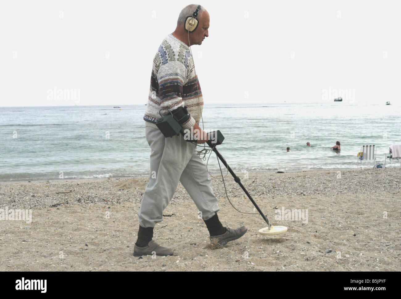 ein Mann mit einem Metalldetektor am Cornish Strand Stockfoto