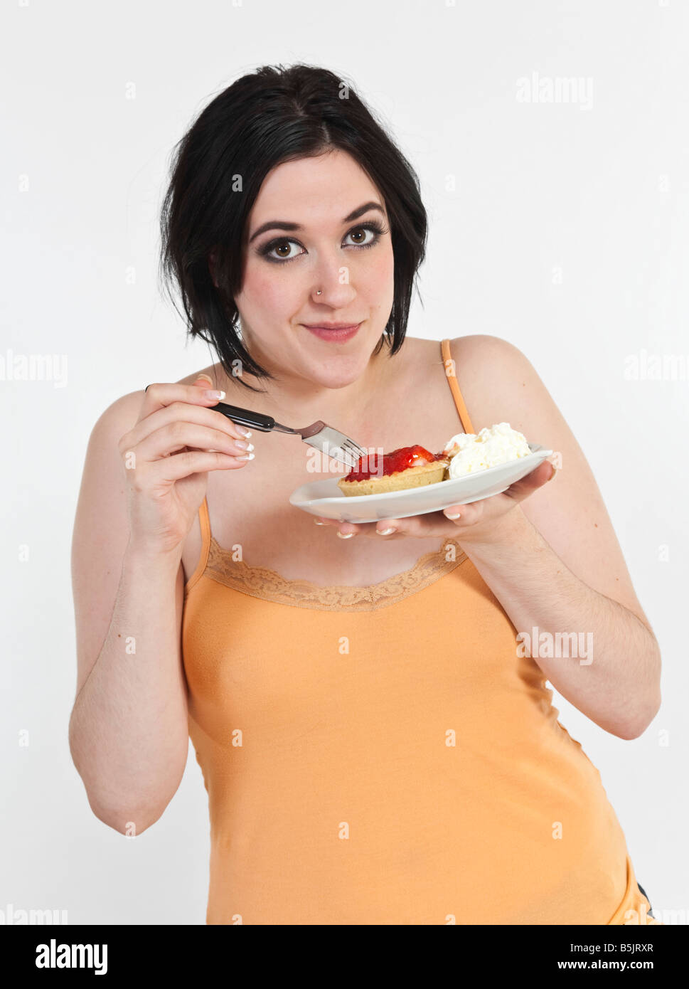 Sexy junge Frau isst eine Erdbeere-Torte mit Sahne Stockfotografie - Alamy