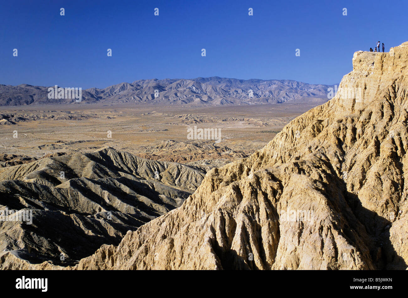 Wanderer an Stelle der Schriftarten in Borrego Badlands mit Vallecito Berge in Ferne an der Anza Borrego Desert Staatspark Kalifornien USA Stockfoto