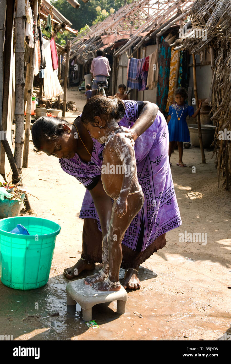 Tsunami Vertriebenen Frau wäscht ihr Kind außerhalb ihrer Zuflucht in Flüchtlingslager in Nagapattinam Tamil Nadu, Indien Stockfoto