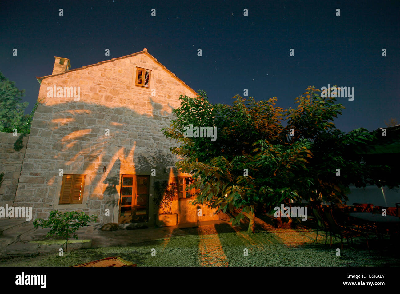 Nachtaufnahme des Hauses mit Palme Baum Schatten der Mauer gegossen Stockfoto