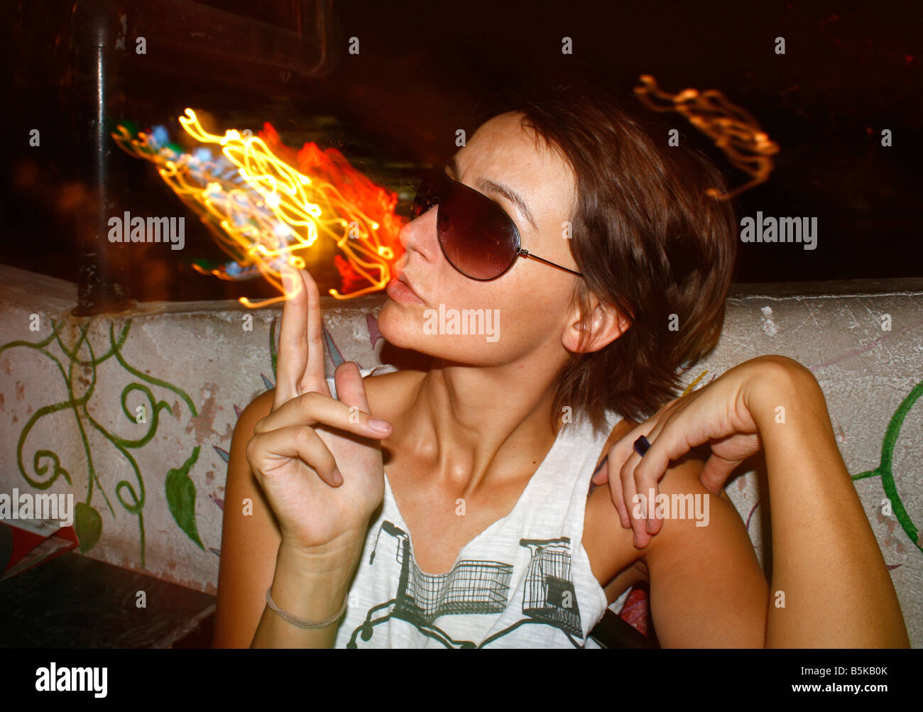 Junge Frau Rauchen einige bunte Hallucinegenic kosmische Licht Substanz Stockfoto
