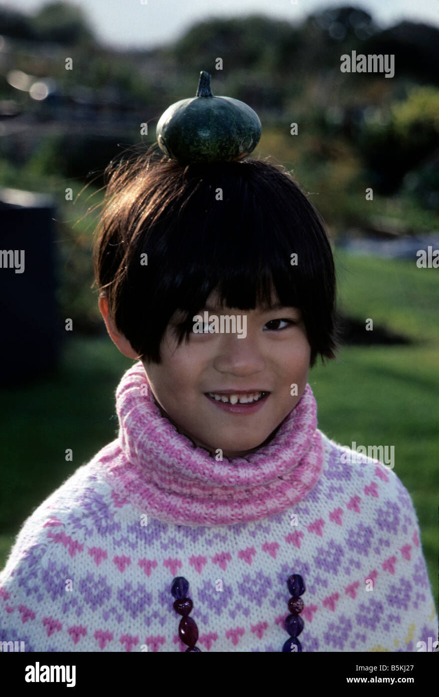 Ziemlich chinesischen Mädchen einen Kürbis auf dem Kopf balancieren Stockfoto