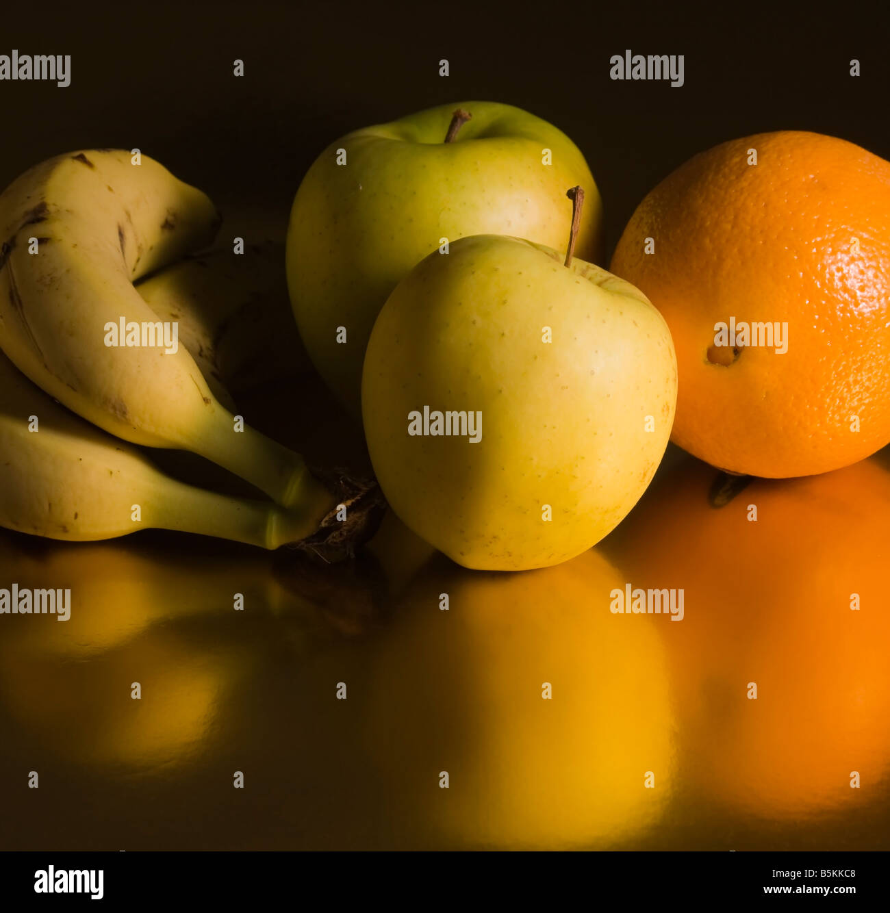 Frisches Obst drei Bananen zwei Äpfel eine orange Stockfoto