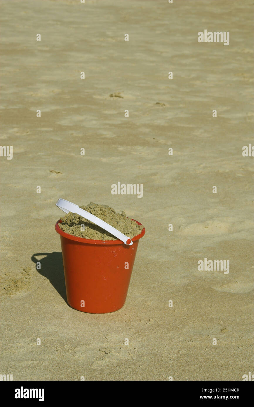 Roten Eimer voll Sand bereit, eine Sandburg bauen Stockfoto