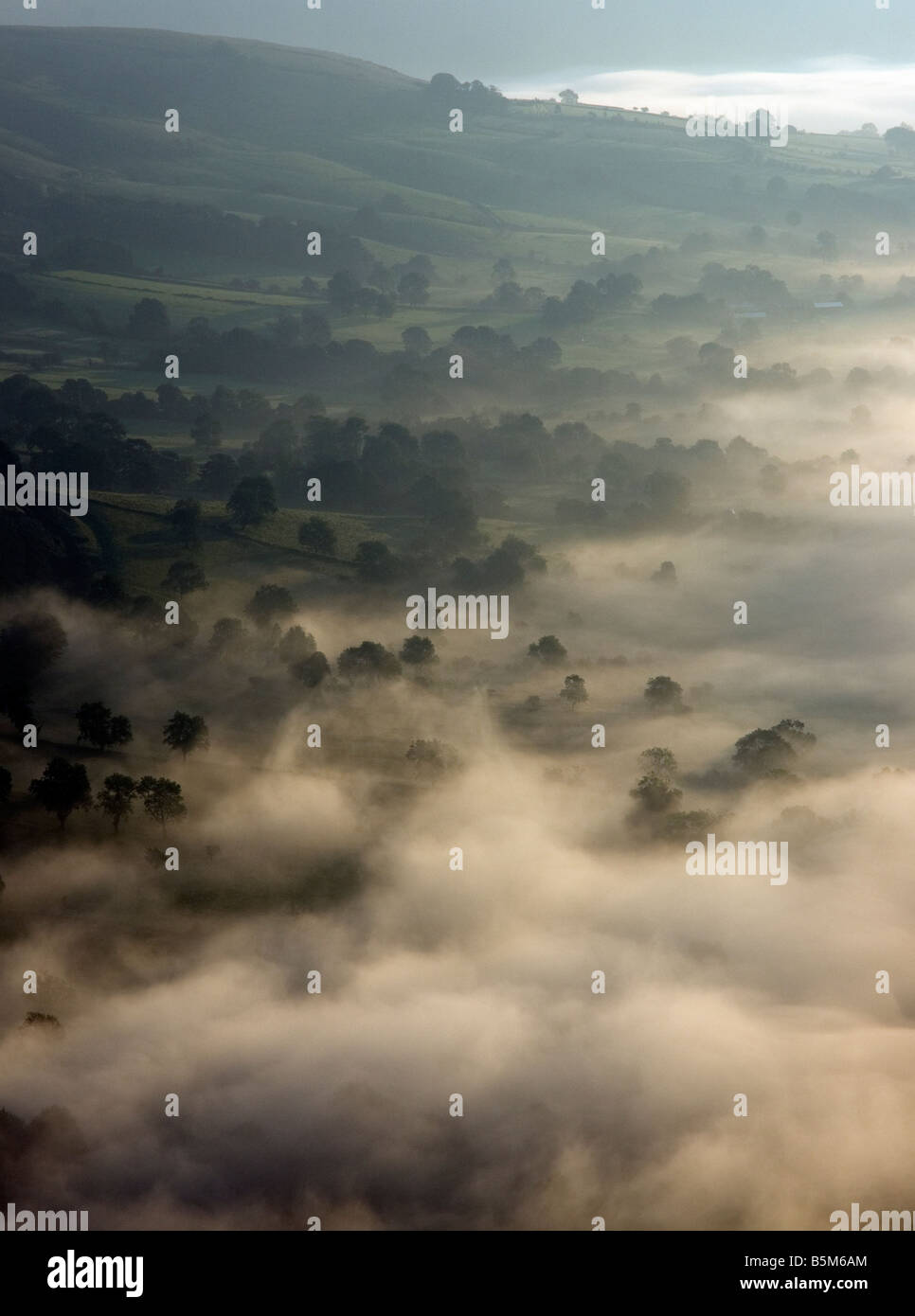 von Mam Tor blickt verlieren Hügellandschaft im Morgengrauen mit Morgennebel und stimmungsvoller Beleuchtung im Peak District park Stockfoto
