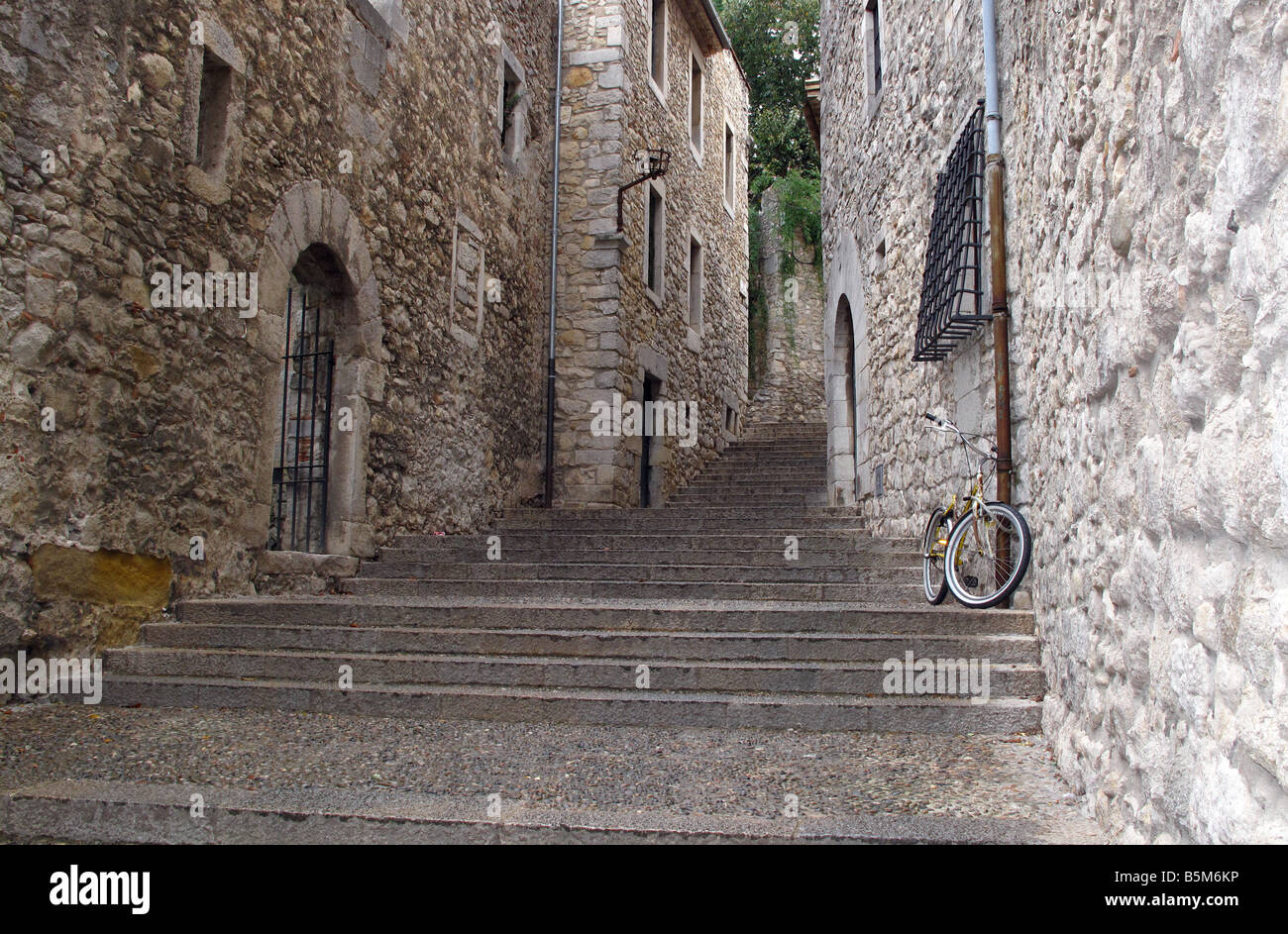 Fahrrad auf breiten Steinstufen führen durch eine verlassene Straße in der Altstadt von Girona, Katalonien, Spanien. Stockfoto