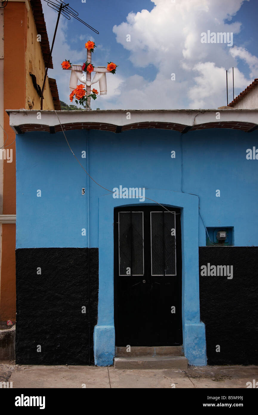 Ein blaues Haus mit schwarzen Tür und Kreuz mit orangen Blüten in Ajijic Mexiko Stockfoto