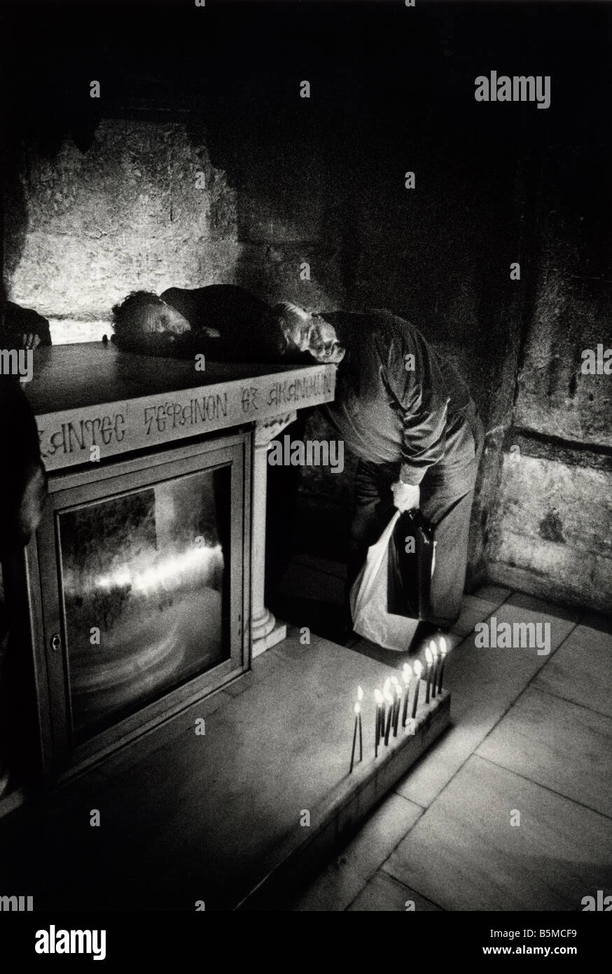 Pilger legen ihre Ohren auf den Stein von der Mocking, auf denen Christus geschlagen wurde. Die Grabeskirche, Jerusalem, Israel Stockfoto
