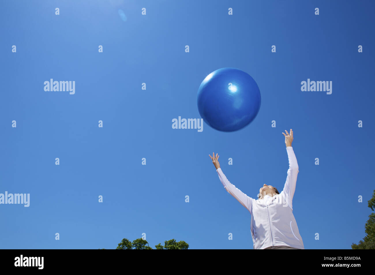 Ältere Frau warf einen Gymnastikball Stockfoto