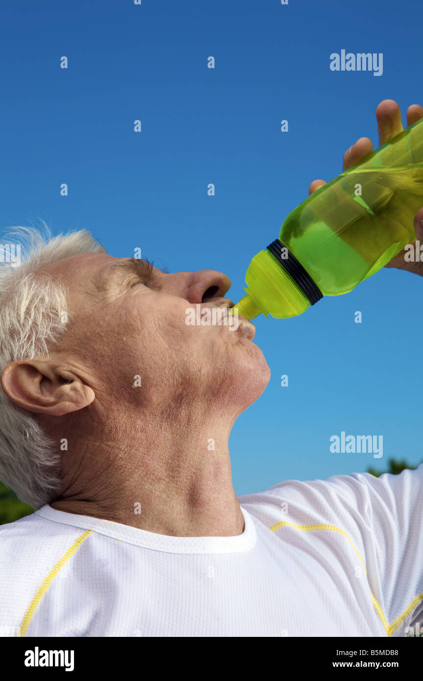 Ein älterer Mann trinkt aus der Flasche Stockfoto