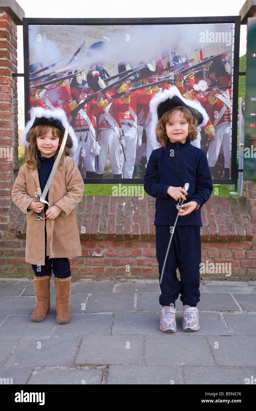 Kinder mit Periode Hüte und Schwertern außerhalb des Besucherzentrums am Ort der Schlacht von Waterloo. Waterloo. Belgien. Stockfoto