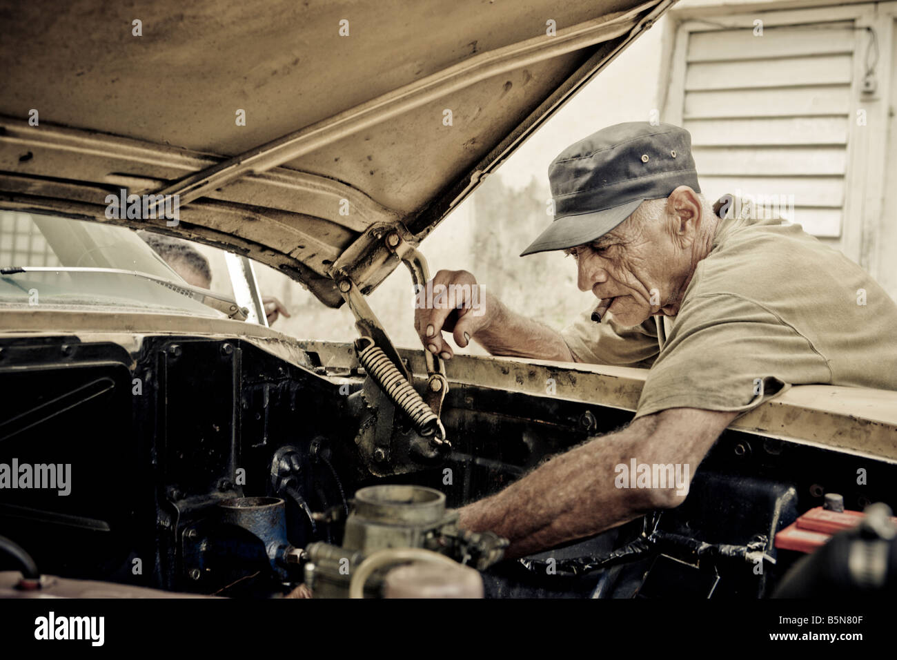 Mann Rauchen Zigarre arbeitet an seinem alten amerikanischen Auto Alt-Havanna-Kuba Stockfoto